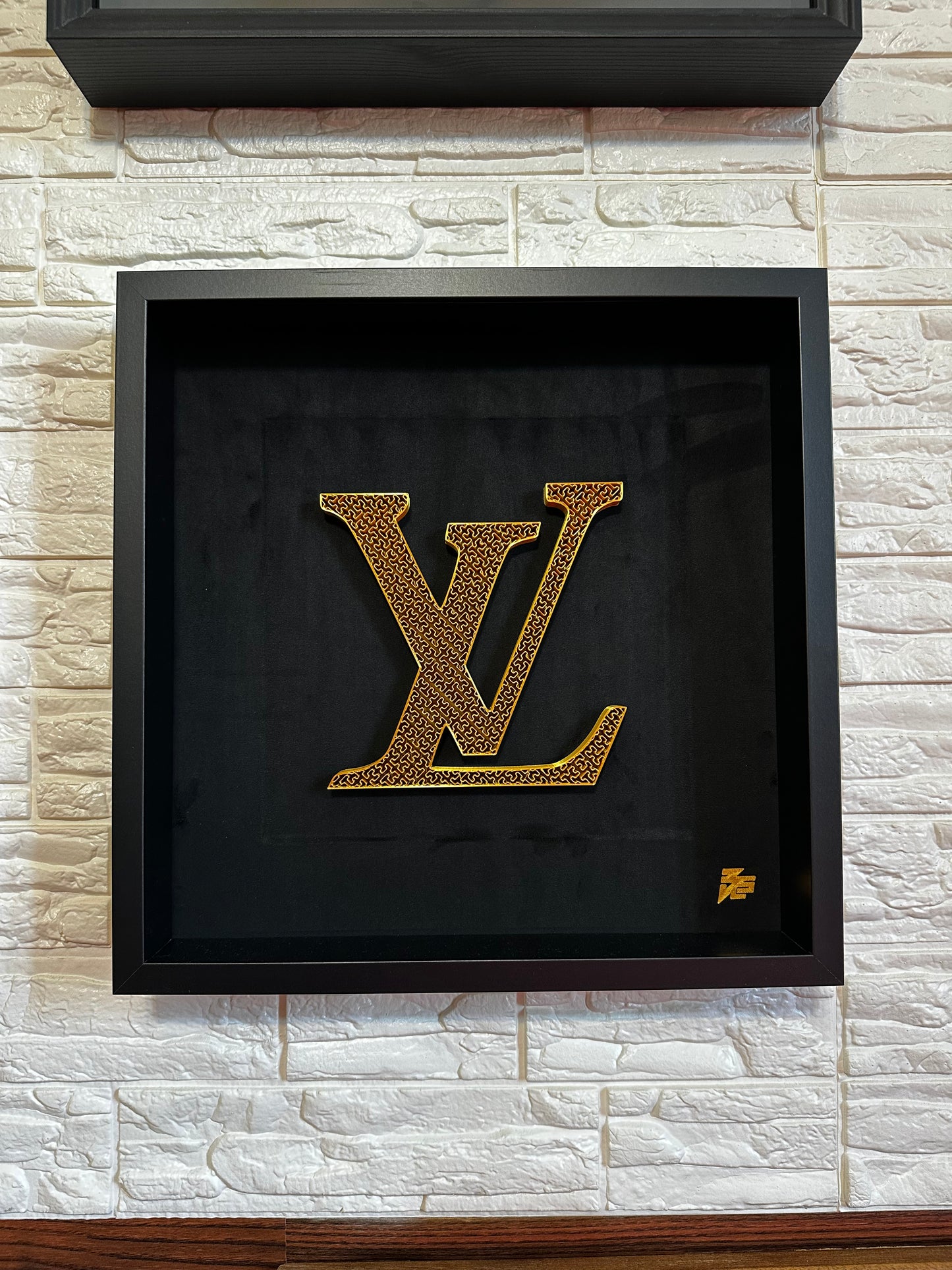 logo Louis Vuitton oro artefatto su sfondo nero